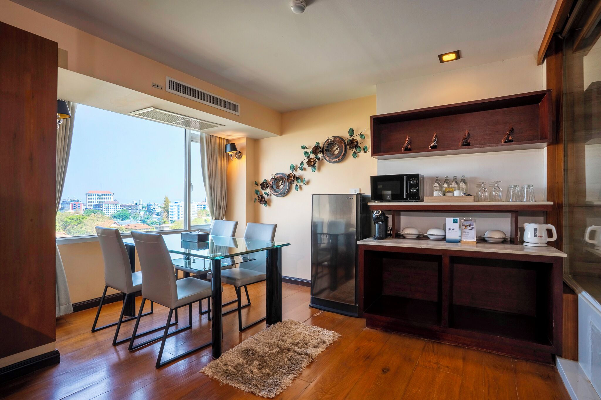 A compact kitchen with a dining area, a refrigerator, and a coffee station.