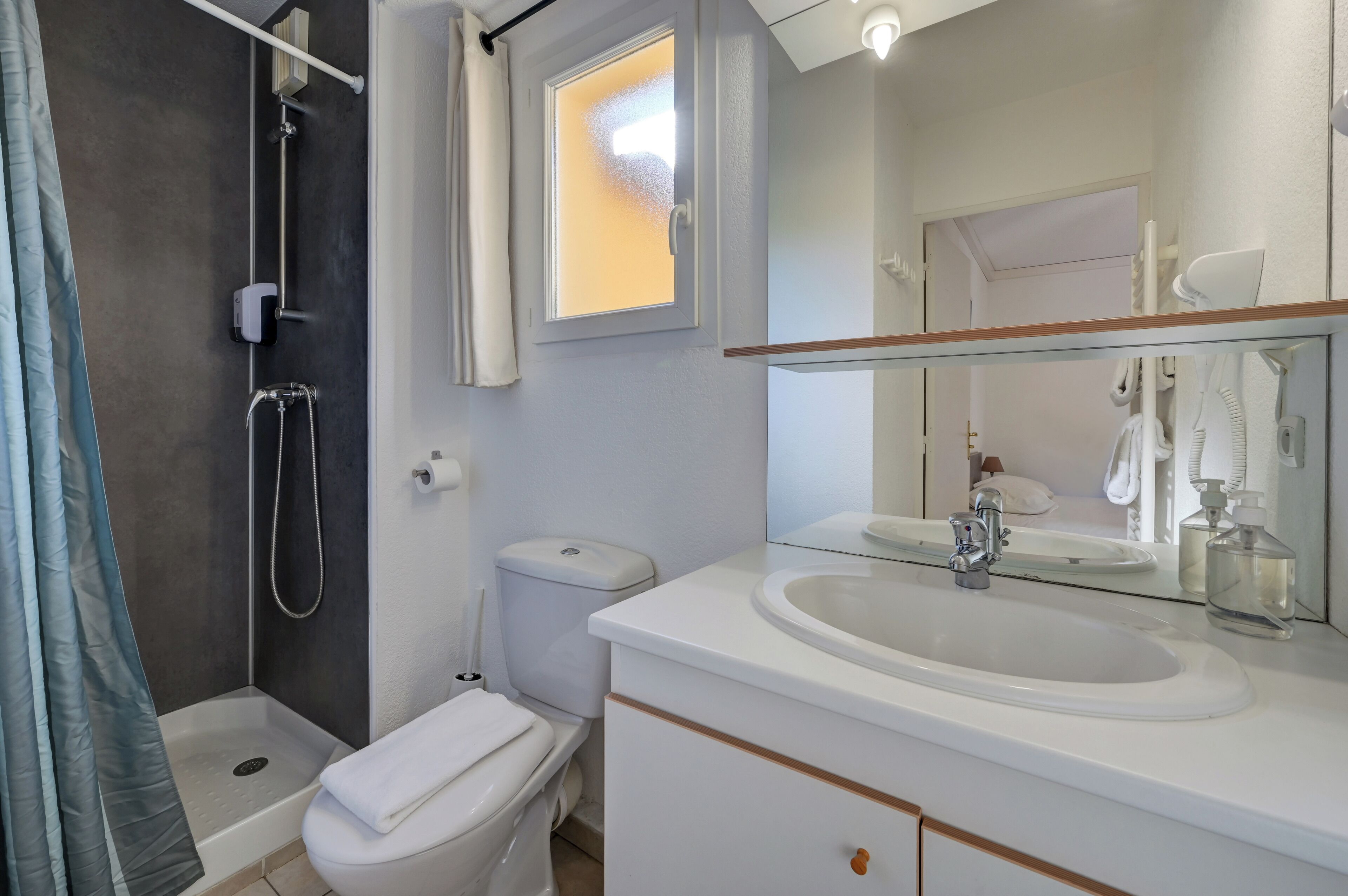 Un baño moderno con ducha, inodoro y lavamanos.