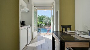 A kitchen with a dining area, a view of a pool, and a door leading to an outdoor space.
