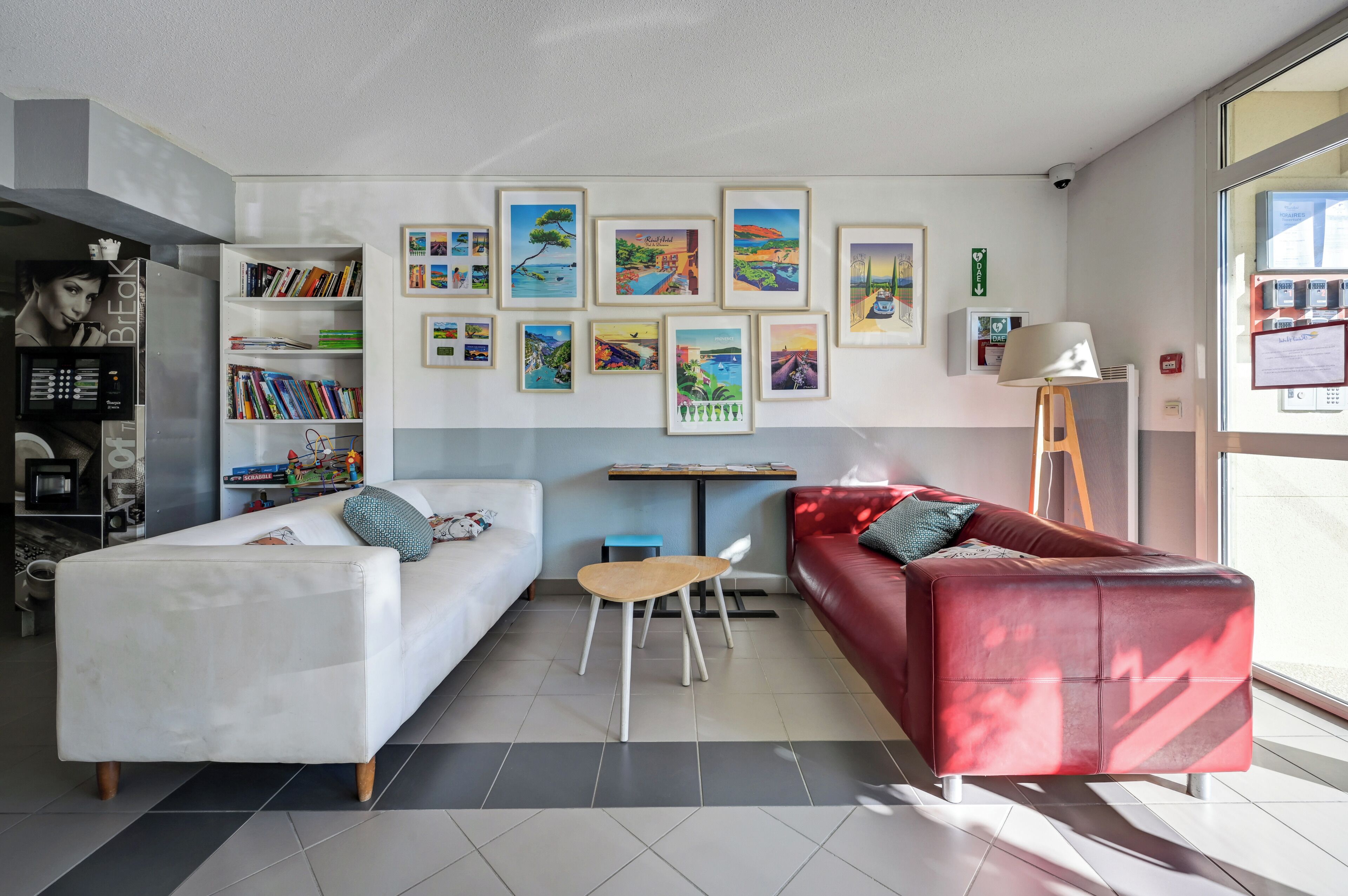 Una sala de estar moderna con un sofá blanco, un sofá rojo, una mesita y una estantería.