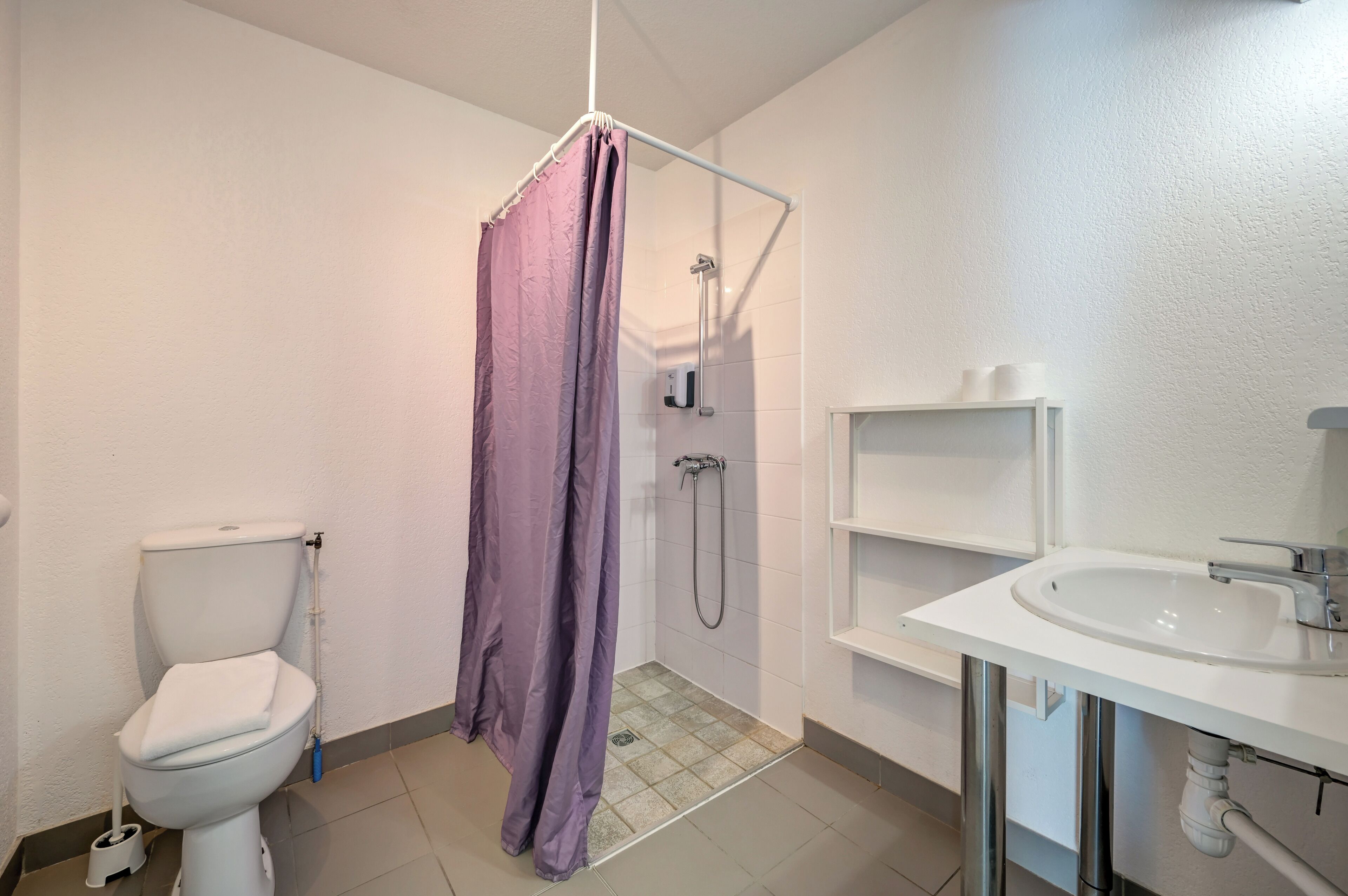 Un baño con inodoro, ducha y lavamanos.