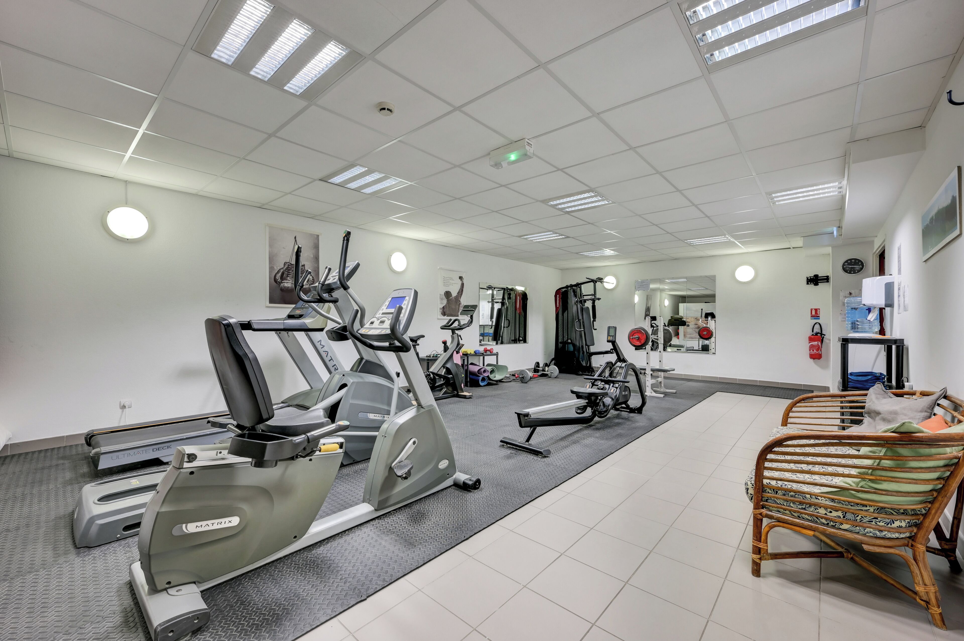 Una sala de fitness amb cintes de córrer, màquines el·líptiques i equip d'aixecament de peses.
