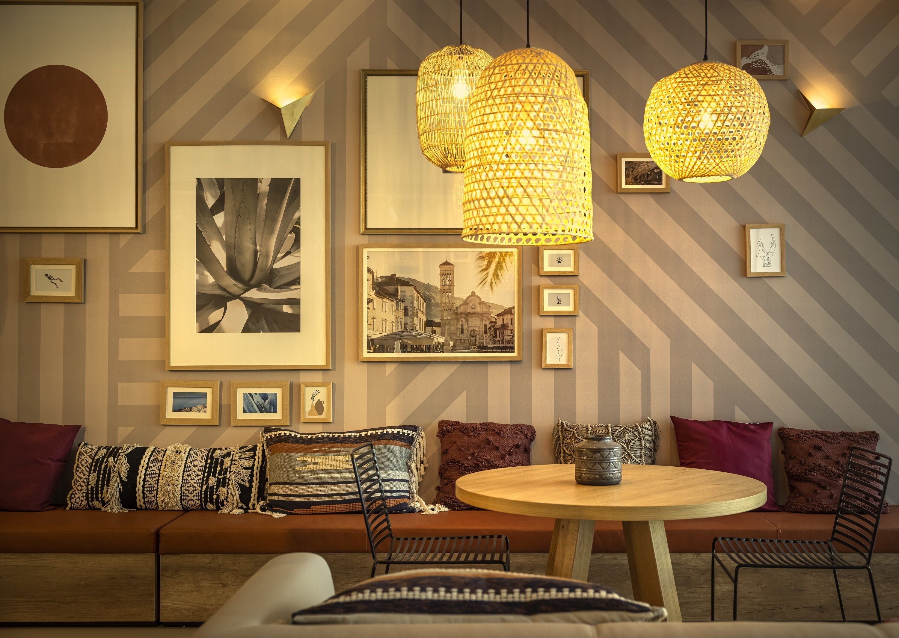 Un salon moderne avec un canapé, une table ronde et des lampes suspendues.