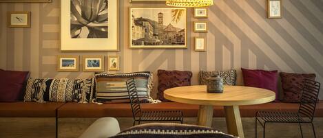 A modern living room with a sofa, round table, and hanging lamps.