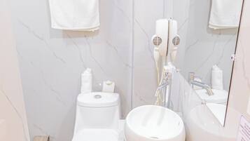 A bathroom with a toilet, sink, and mirror.