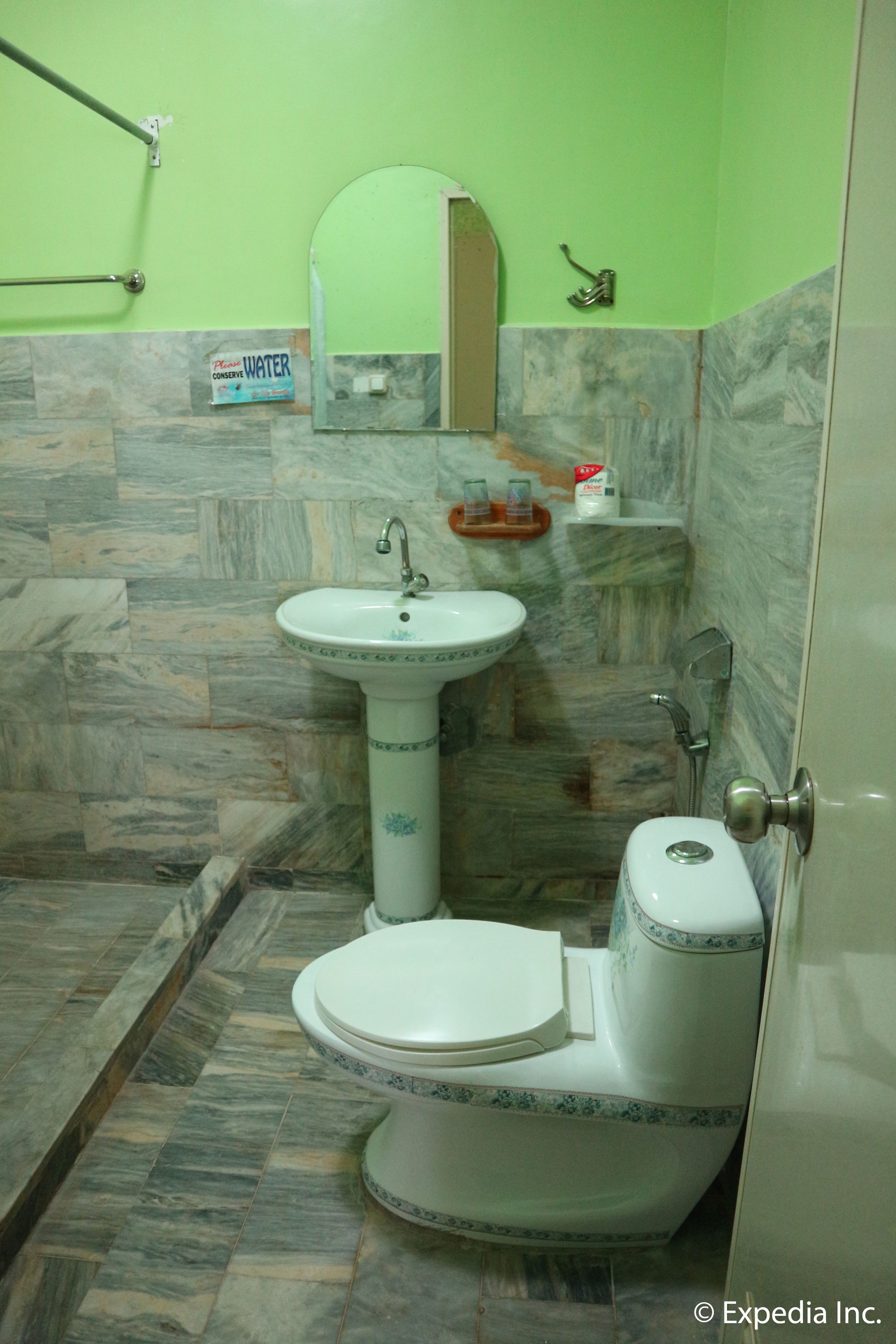A bathroom with a white sink, toilet, and shower.
