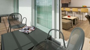 A modern interior with a dining area, a kitchen, and a balcony with chairs. - ibis Styles Zeebrugge (Bruges)
