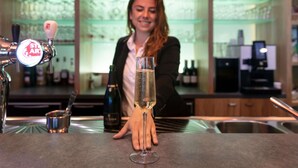 A bar area with a tap labeled 'STAR,' a glass of champagne, and a bottle of wine on the counter. - ibis Styles Zeebrugge (Bruges)