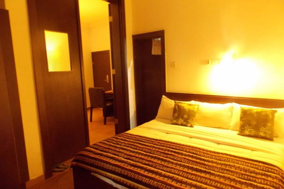 A hotel room with a bed, a desk, and a chair.
