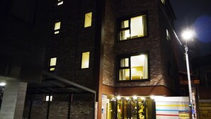 A building with multiple windows, some illuminated. There is a sign for 'LEE&NO Guesthouse' and a visible entrance. - Lee & No Guesthouse (Seoul)