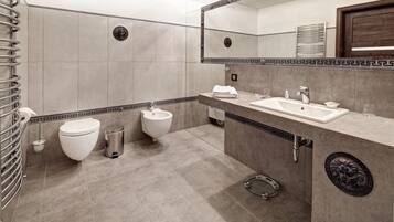 A modern bathroom with a toilet, bidet, and sink.