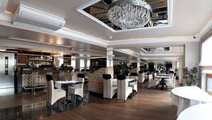A spacious hotel lobby with a high ceiling, chandeliers, and a bar area. - M Hotel Sosnowiec (Sosnowiec)