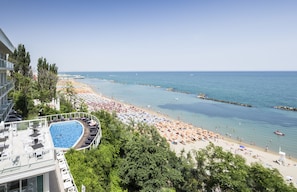 A resort with a swimming pool, beach, and ocean view.