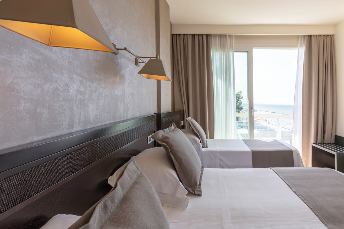 Habitación triple, vista parcial al mar | Ropa de cama de alta calidad y artículos del minibar gratis