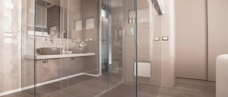 A modern bathroom with a glass shower enclosure, a double sink vanity, and a large mirror.