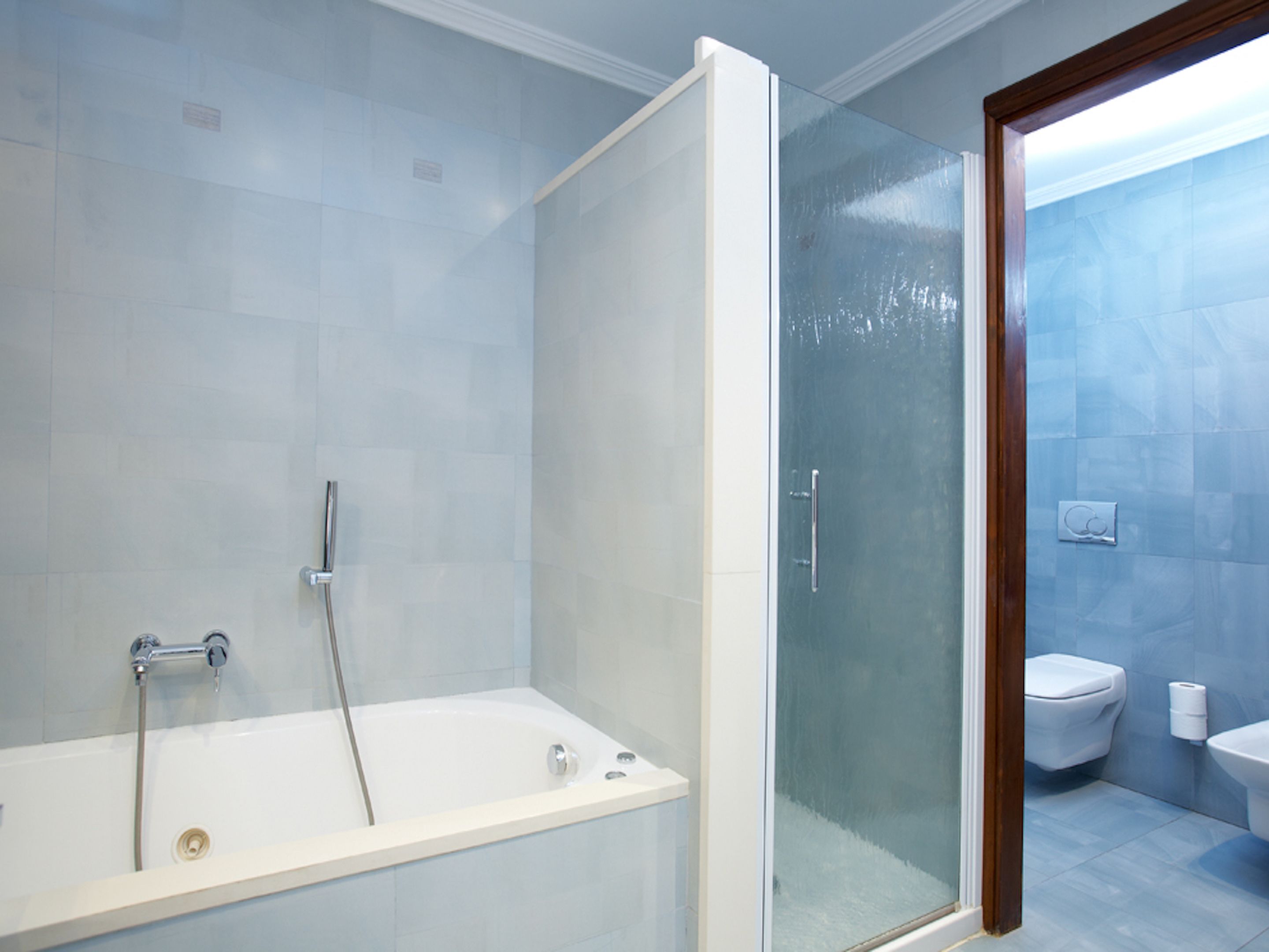 Une salle de bain moderne avec une douche à parois de verre, une baignoire et des toilettes.