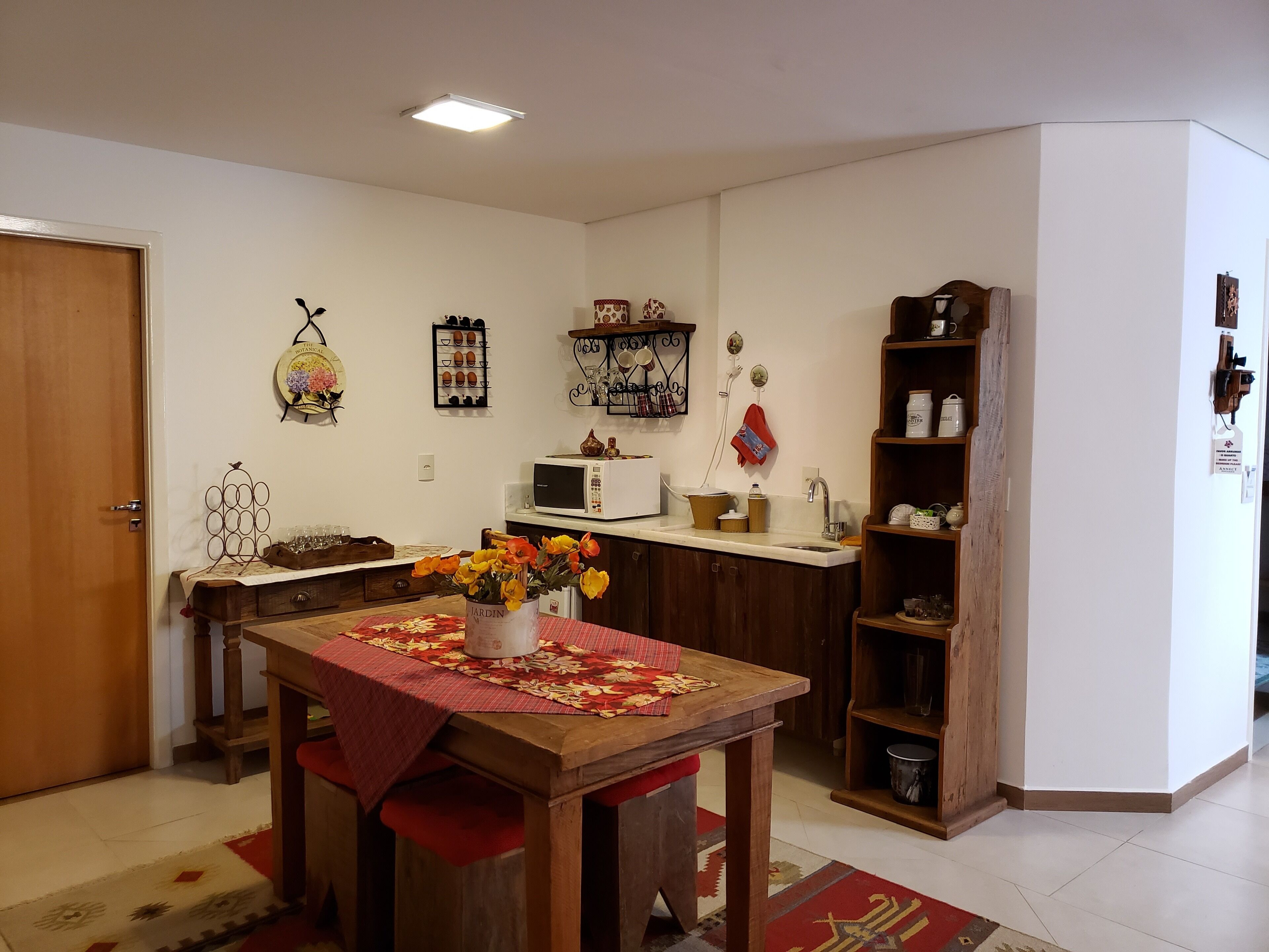 A compact kitchen with a wooden table, a microwave, and a sink.