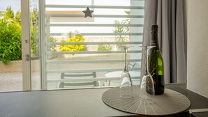A table with a bottle of wine and two wine glasses on a round placemat. - Zodiac Apartamentos (Sant Josep de sa Talaia)
