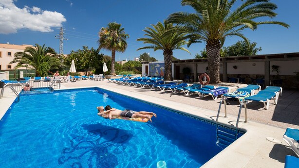 A swimming pool with lounge chairs and palm trees. - Zodiac Apartamentos (Sant Josep de sa Talaia)