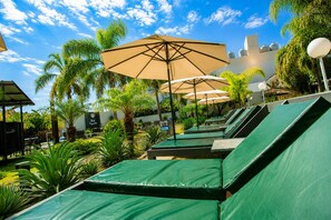 Een buitenzwembad, parasols voor strand/zwembad