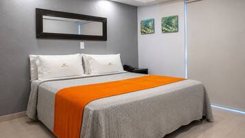 A hotel room with a bed, a nightstand, a telephone, and two wall-mounted paintings.