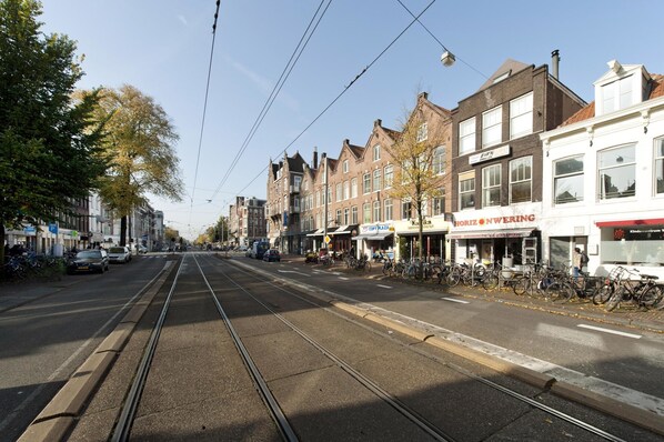 Une rue avec des voies de tramway, des immeubles et des vélos garés.