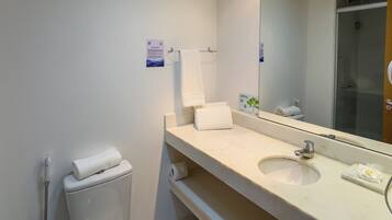 Un baño moderno con inodoro, lavamanos y espejo.