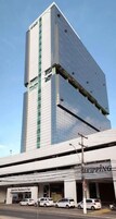 A tall, modern building with a flat facade and large windows.