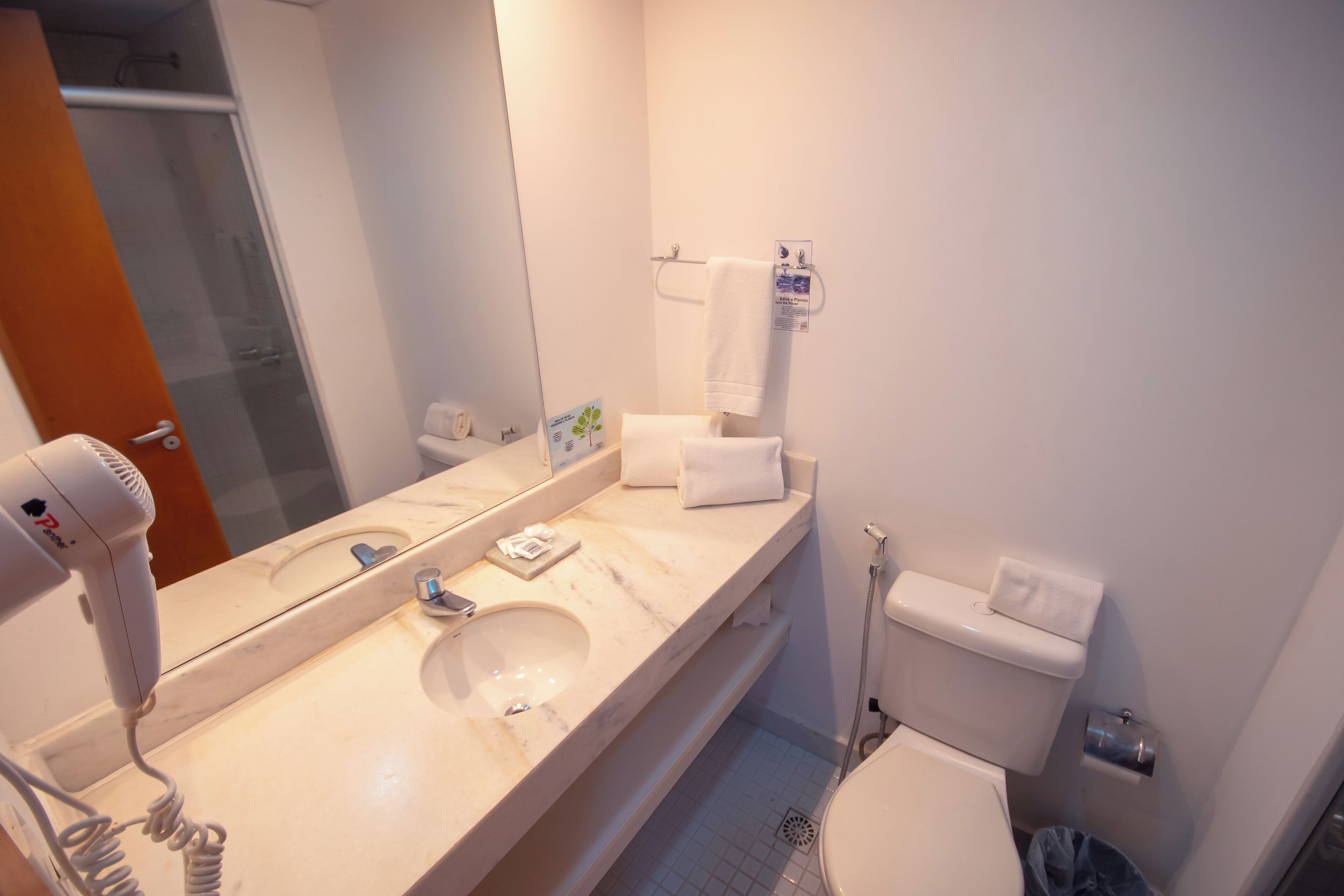A bathroom with a sink, mirror, towel rack, and toilet.