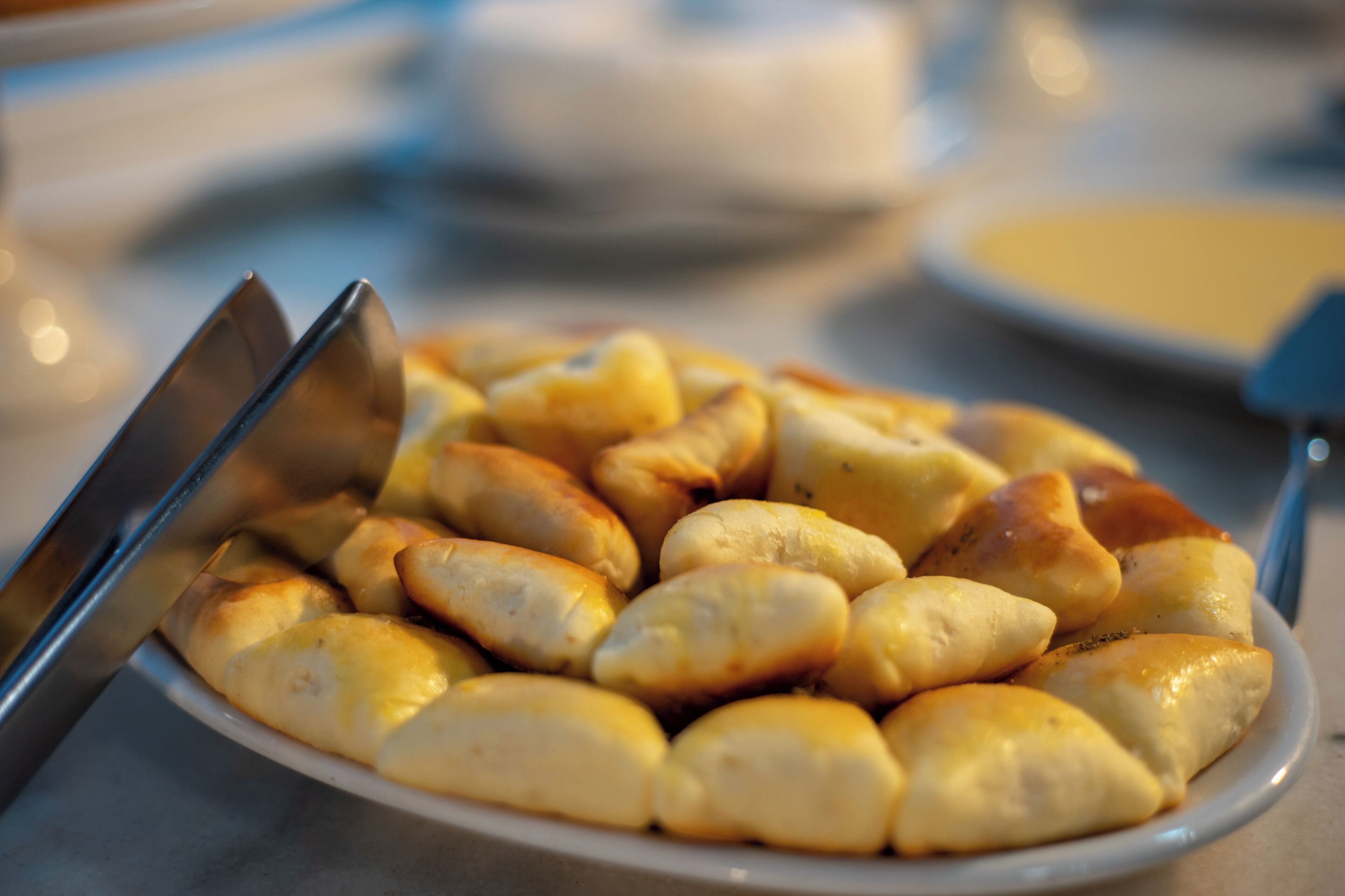 Un plato de bollería dorada sobre un plato blanco.