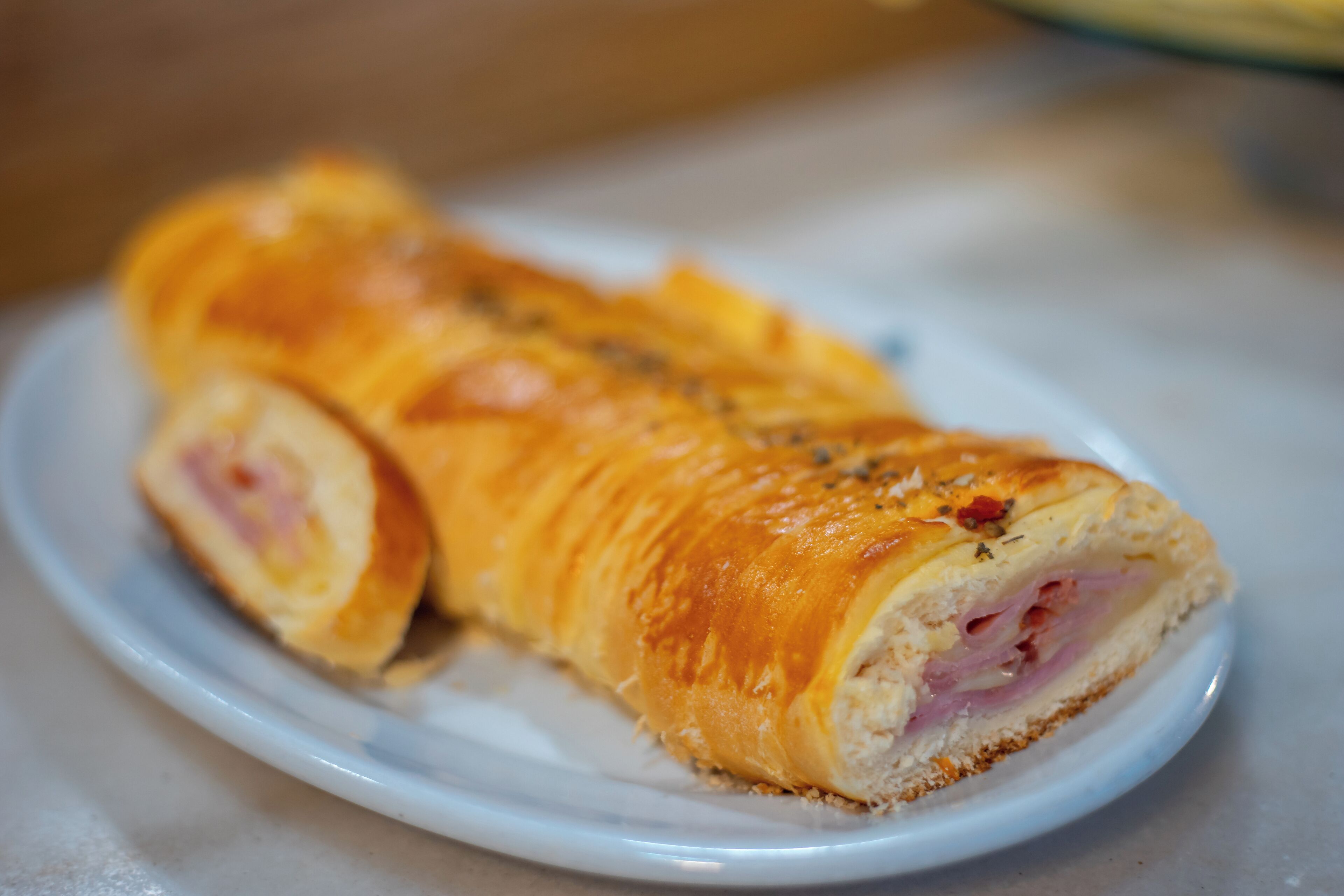 A sliced pastry with visible layers and seasoning on a plate.