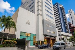 A modern building with a sign for Salvador Business & Flat.