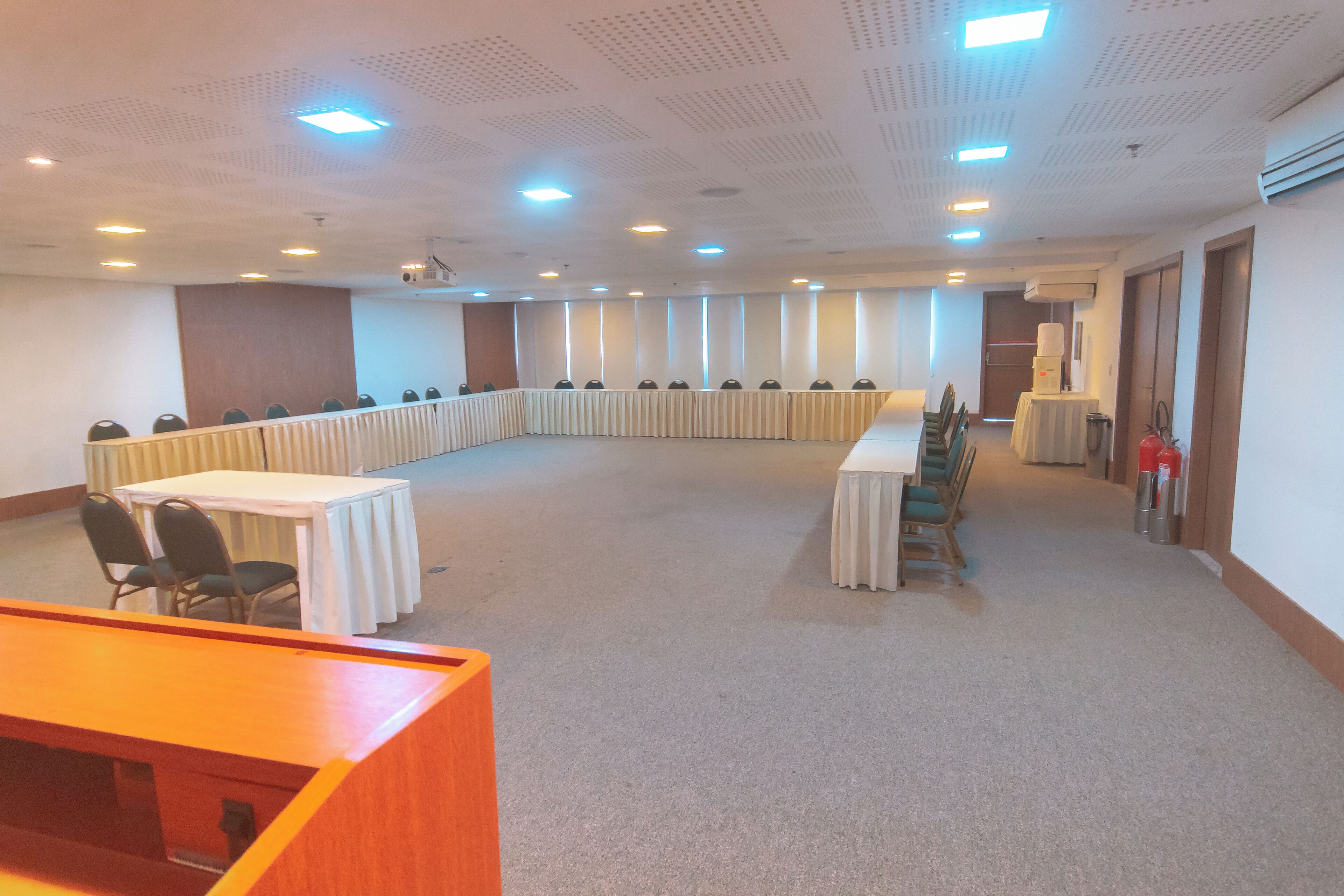 A conference room with a long table, chairs, and a podium.