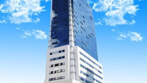 Un immeuble moderne et imposant, doté d’une façade en verre et de plusieurs étages.