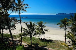 Rannalla, aurinkotuoleja, aurinkovarjoja, rantapyyhkeitä