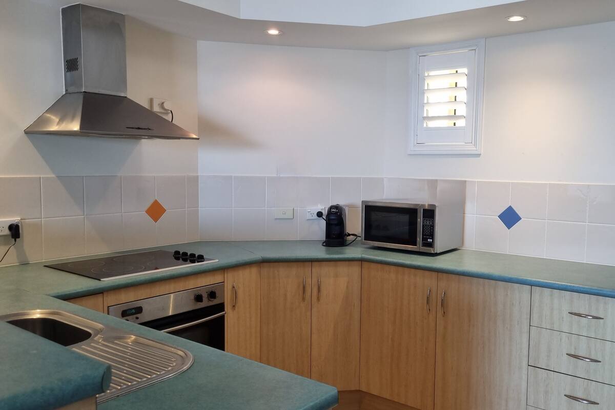 A compact kitchen with a gas stove, a microwave, and a built-in oven.