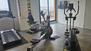 A gym with a treadmill, elliptical, and stationary bike.