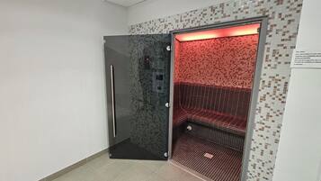 Ein moderner Aufzug mit einer Metalltür und einem rot beleuchteten Innenraum.