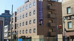 A hotel building with multiple floors, a prominent sign for Hotel Nobles Chofu, and a banner advertising Hotel Livemax. - HOTEL LiVEMAX Chofu-Ekimae (Chofu)
