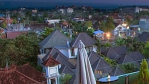 A residential area with houses and a view of the sea at dusk.