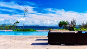 A pool area with a view of the ocean and a clear sky. - LiVEMAX AMMS CanNa Resort Villa (Ginoza)