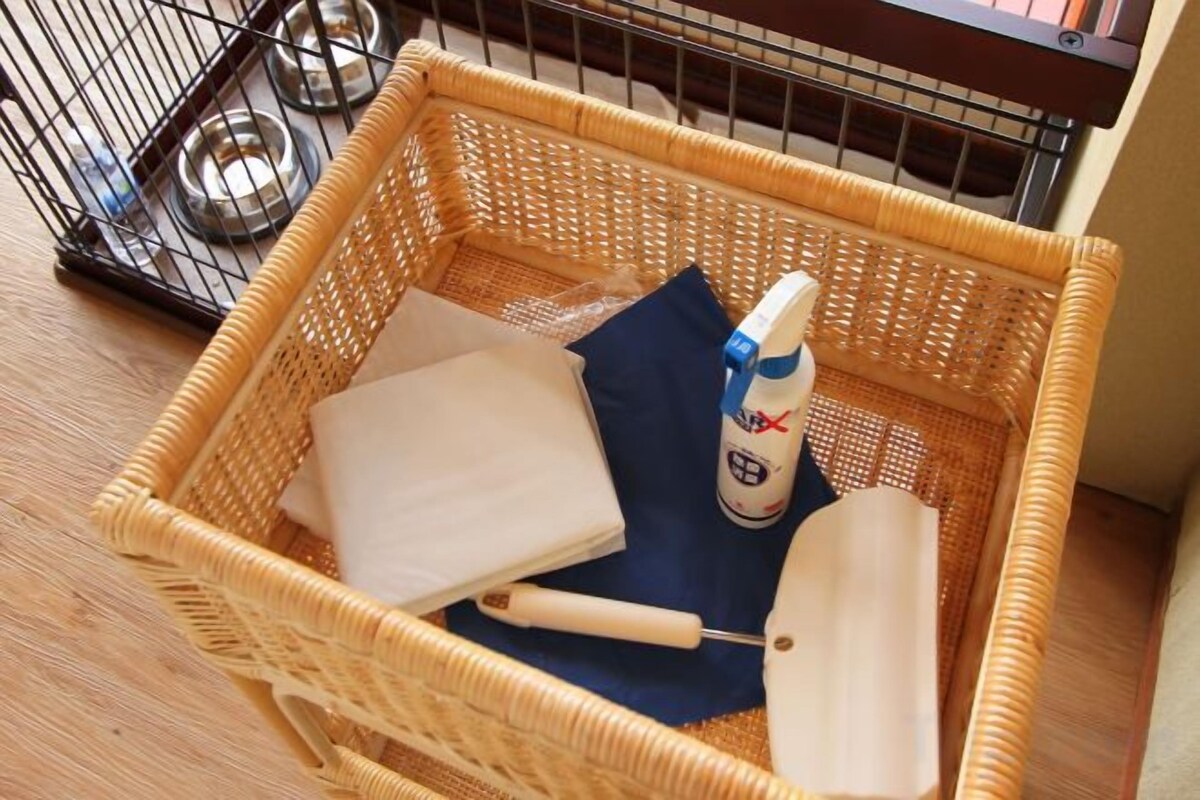 Een rieten mand met een fles, een witte doek en een blauwe doek.