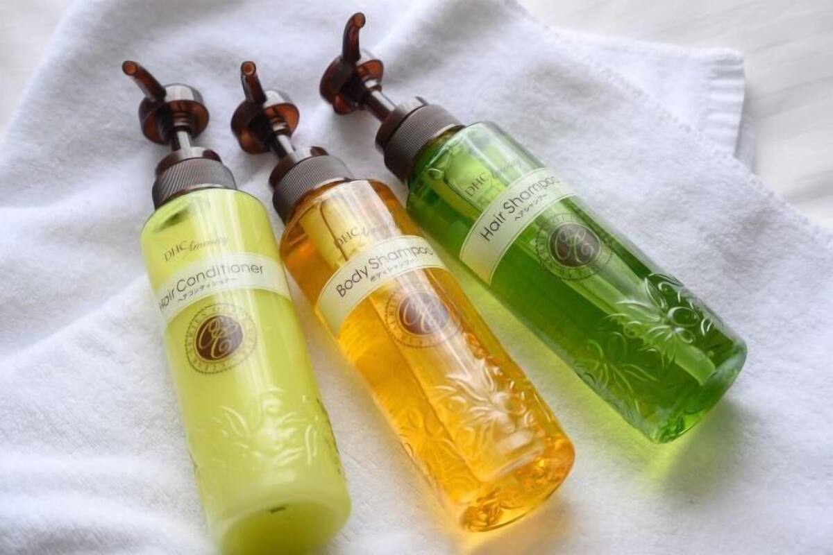 Trois flacons d’après-shampoing sur une serviette blanche.