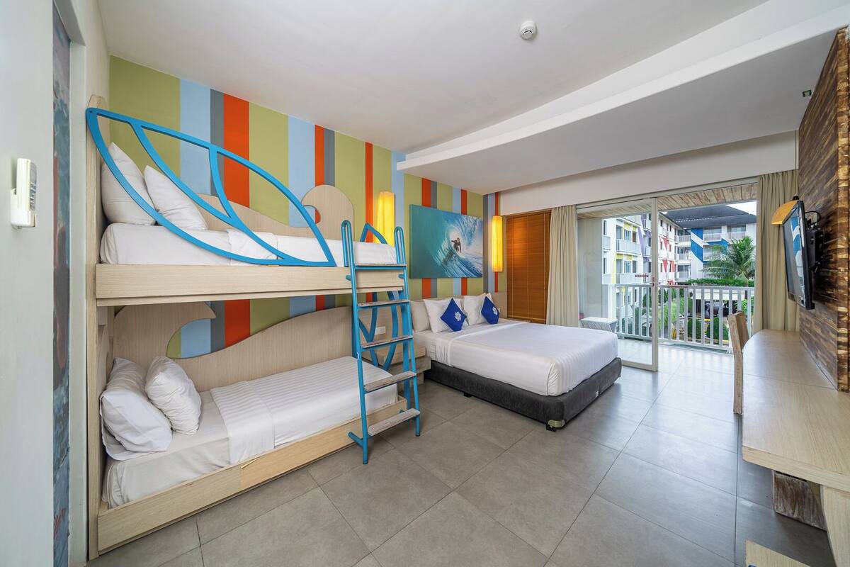 Een hotelkamer met stapelbedden, een balkon met uitzicht en een televisie.