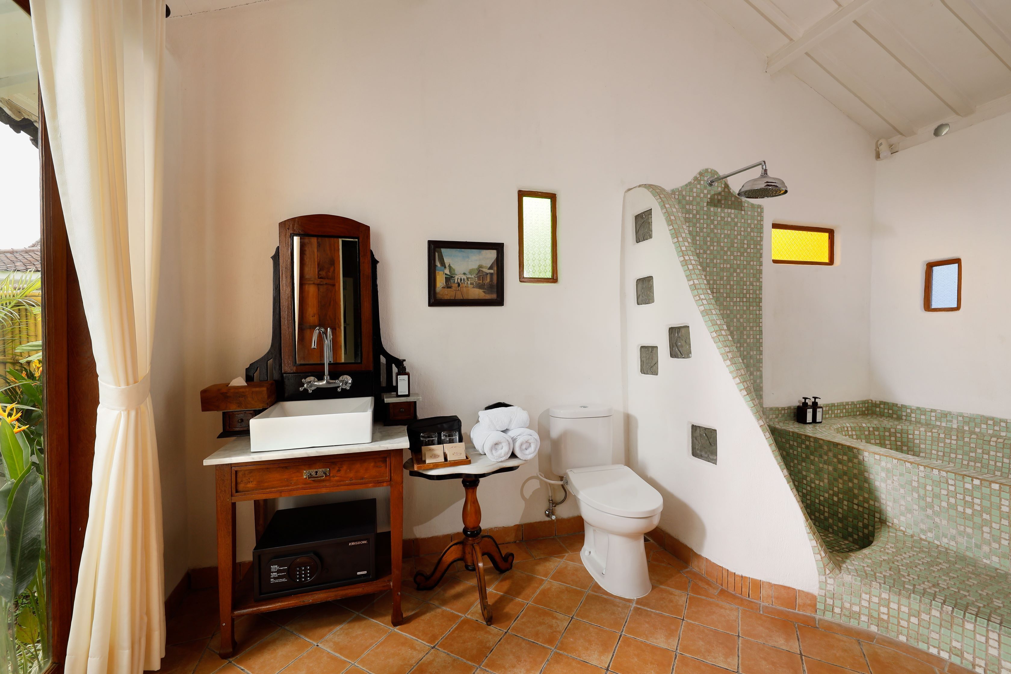 Un baño con inodoro, lavamanos y zona de ducha.