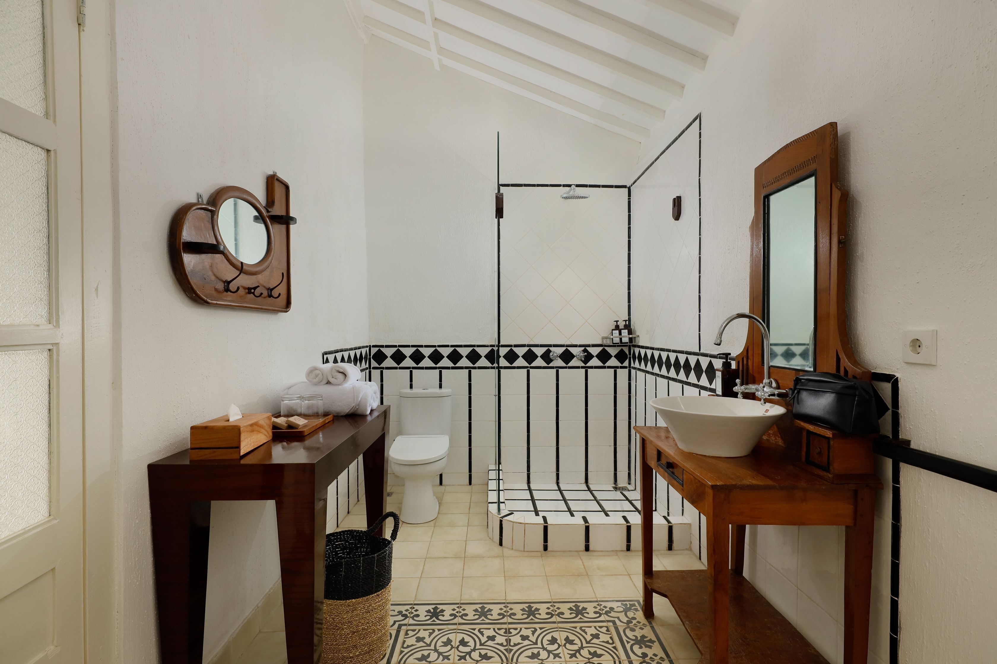 Een badkamer met een houten wastafelmeubel, een wastafel, een toilet en een douche.