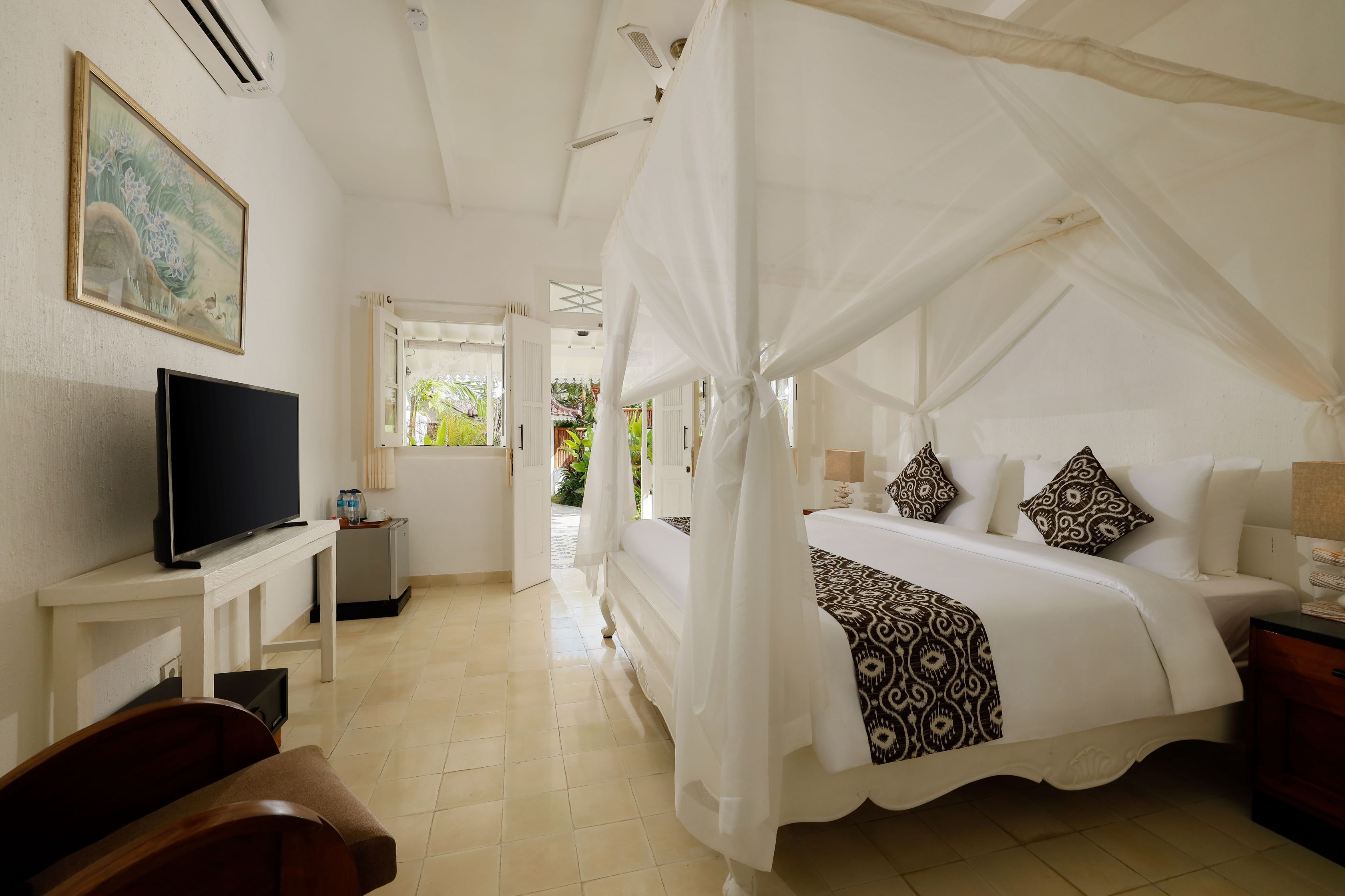 A bedroom with a four-poster bed, a television on a bedside table, and a painting on the wall.