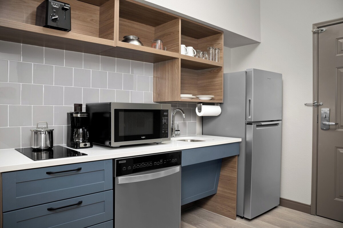 A modern kitchen with a dishwasher, microwave, and refrigerator.