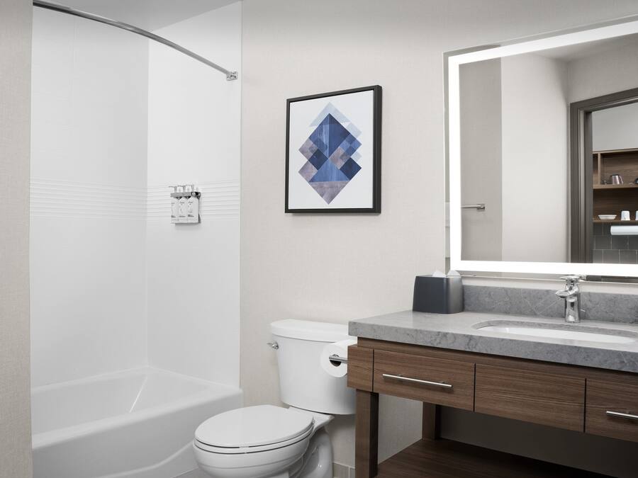 Un baño moderno con bañera, inodoro y tocador.