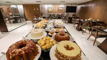 Un bufé con diversos postres y platos.